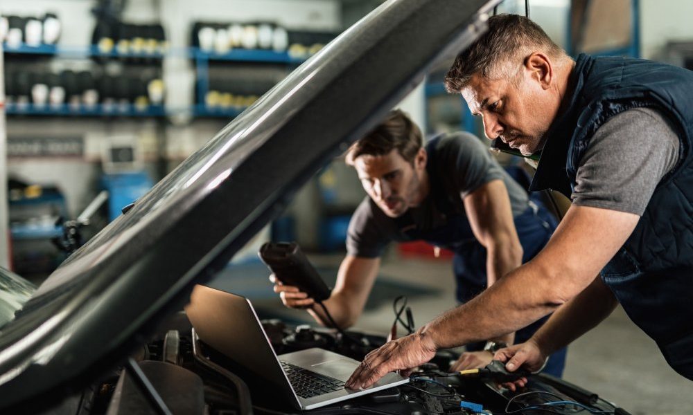 auto-mechanic-using-laptop-cooperating-with-coworker-while-doing-car-diagnostic-repair-shop (1)